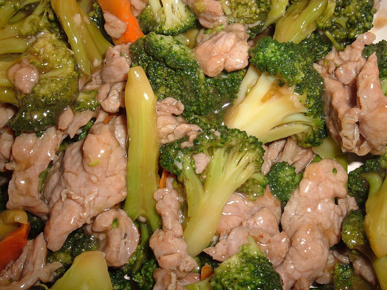 Beef and broccoli stir fry with glossy sauce in a pan.