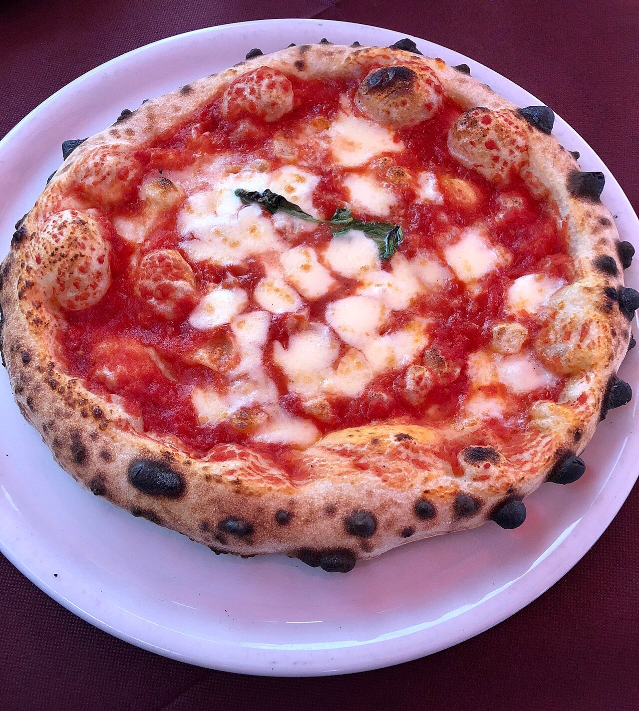 Margherita flatbread pizza with basil and melted mozzarella.