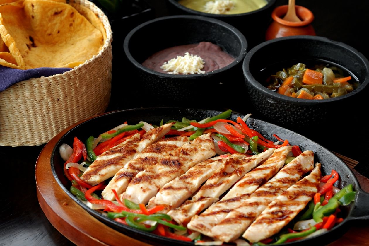 Sizzling chicken fajita strips with charred peppers and onions.