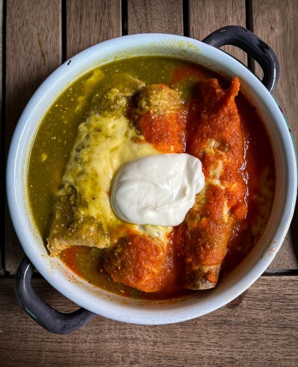 White chicken enchiladas covered in creamy sauce with melted cheese.