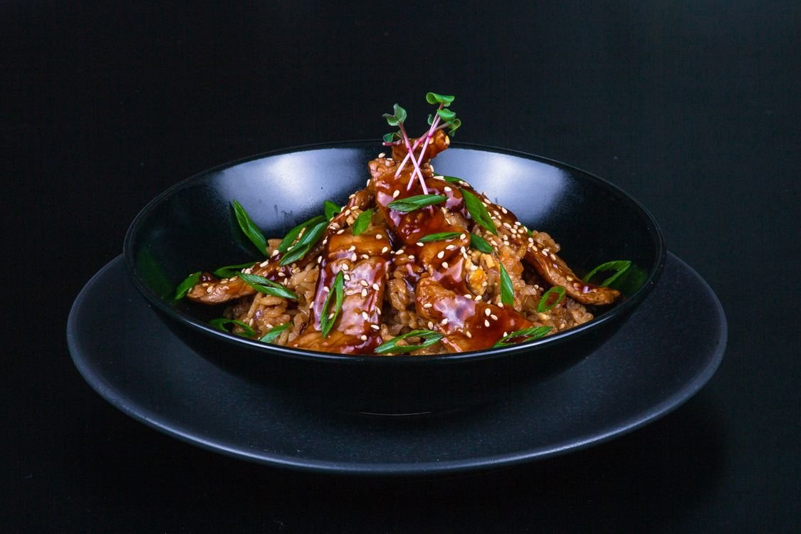 A teriyaki rice bowl with glazed turkey and colorful vegetables.