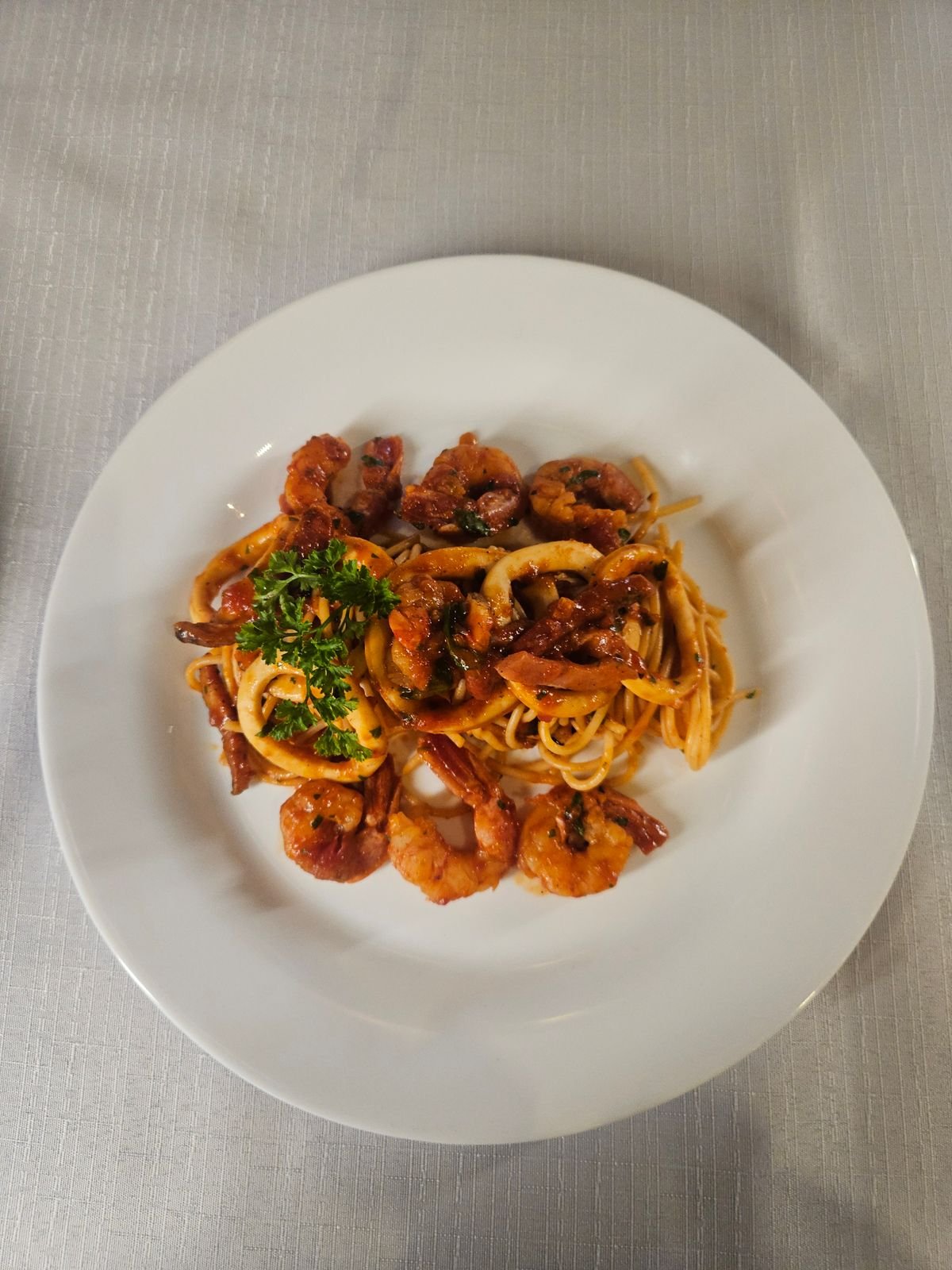 A plate of shrimp pasta with fresh herbs and plump shrimp.