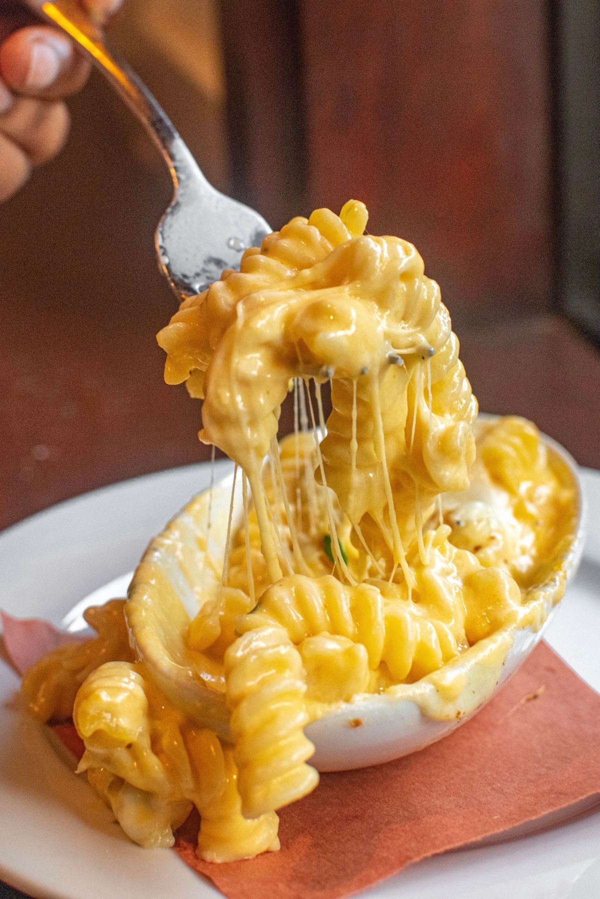 A close-up bowl of cheesy taco pasta with melted cheese.