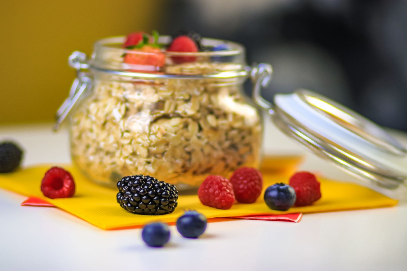 Glass jars of overnight oats topped with fresh fruit and berries.