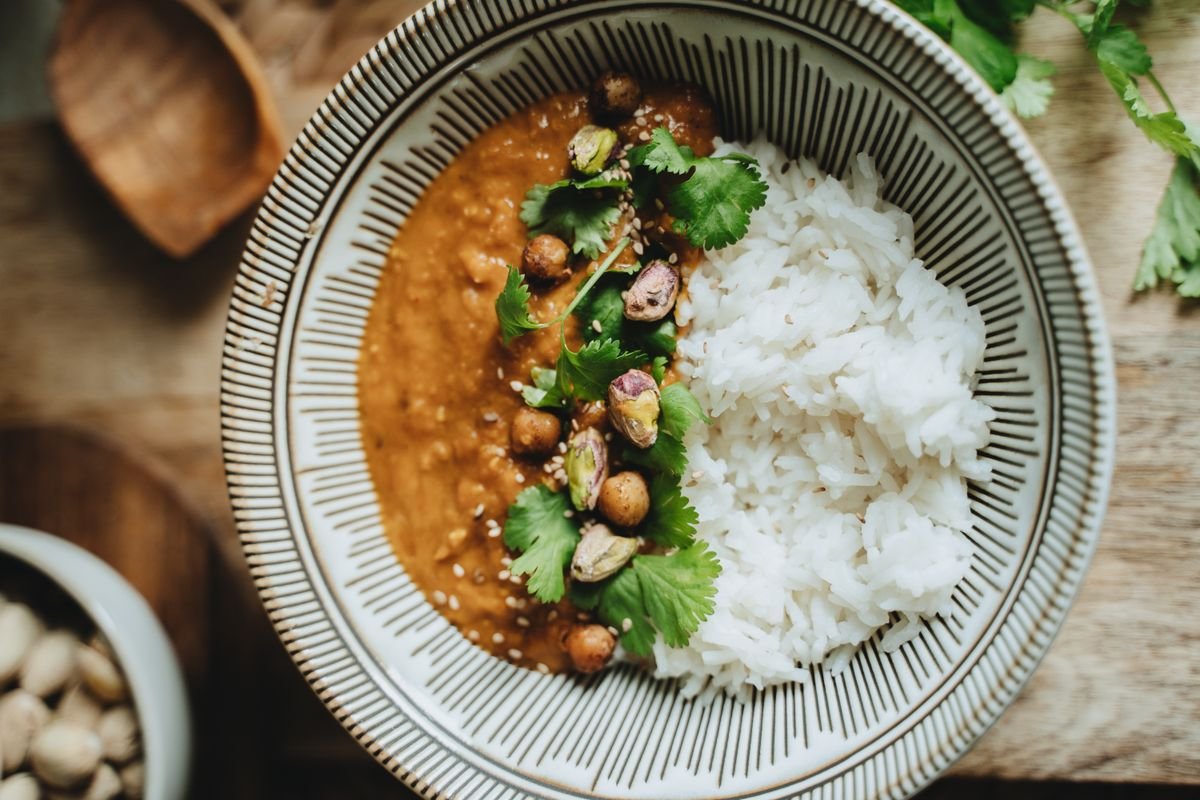 A bowl of lentil curry with rice and fresh cilantro garnish.